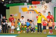 (左起)運動員代表陳國明(桌球)、劉少維(壁球)、馬國寶(滑浪風帆)、「體育的風采 – 東亞運前奏」主持陳柏宇、張瑞(乒乓球) 和王俊喬(七人欖球)與扮演運動員的小朋友合照。