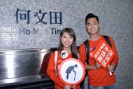 （左起）譚嘉儀、鄭俊弘提醒長者使用扶手電梯時應「握扶手　企定定」，切勿站近梯級邊緣。