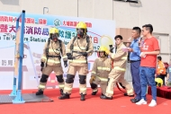 伍允龍（右三）手持消防喉筆從旁協助消防員示範破門，市民均被他們的專業示範所吸引。